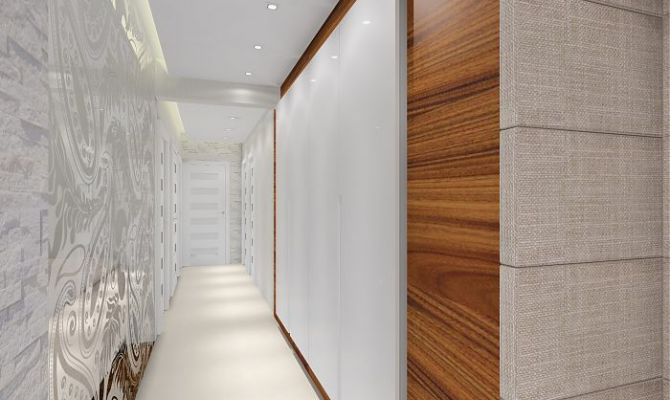 Projekt przytulnego apartamentu z dodatkiem naturalnego kamienia oraz szklaną przesłoną oddzielającą salon od holu. Na filarze dekoracyjny 